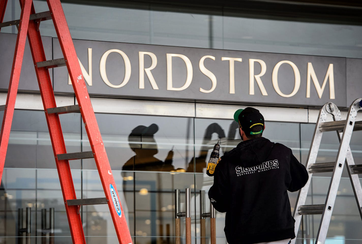 A worker puts up a sign over the door at the new Nordstrom store at Ridgedale in Minnetonka.