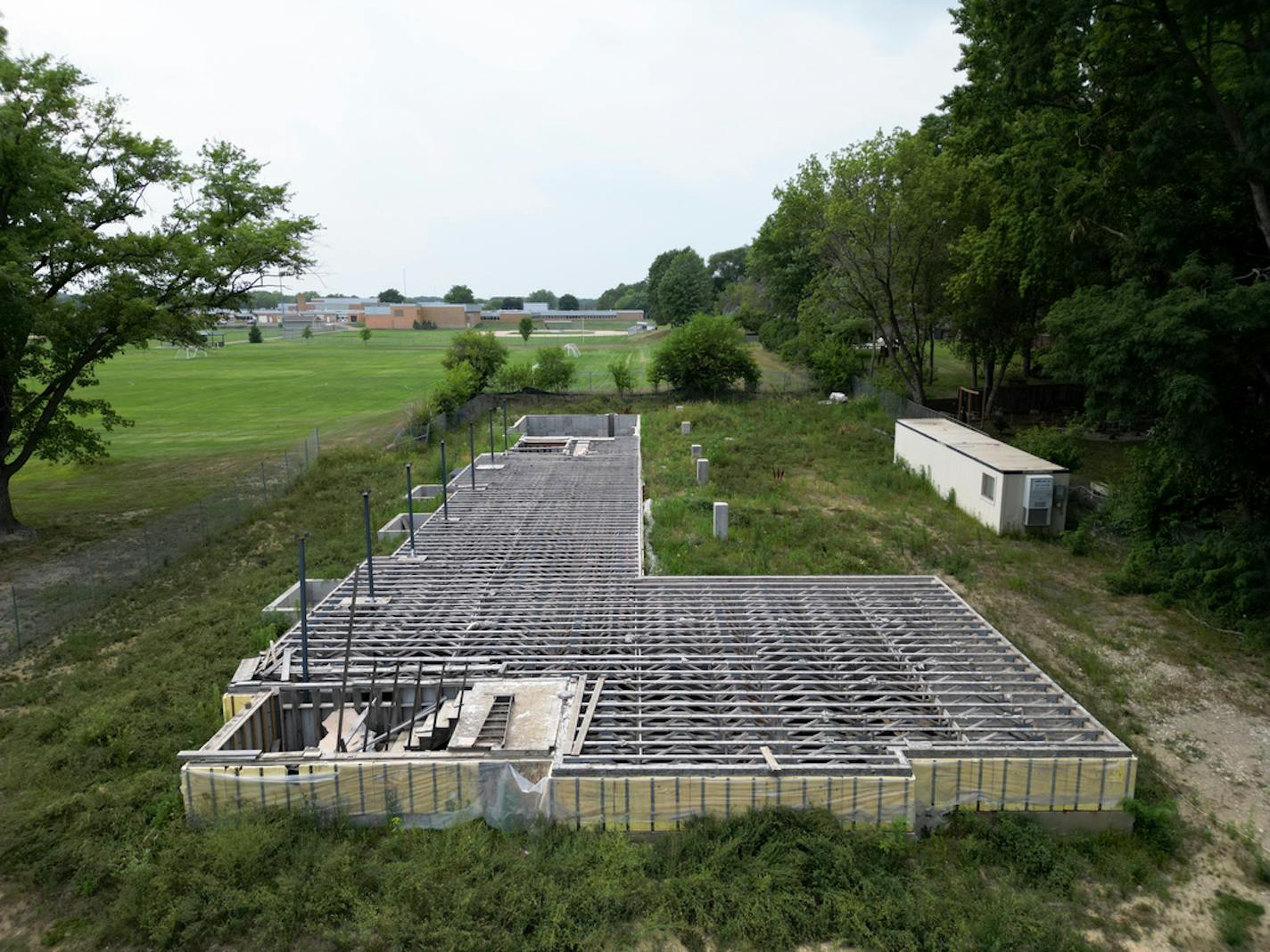 The concrete foundation of senior home that was never finished is photographed Monday, July 24, 2023 in Golden Valley, Minn.. Construction of the senior home stopped two years ago, leaving a neighborhood mystery and nuisance. Builders dug out a basement, poured a foundation and framed out two stories before abandoning the site. The concrete basement is all that remains. The city declared the site hazardous last week. ] AARON LAVINSKY • aaron.lavinsky@startribune.com