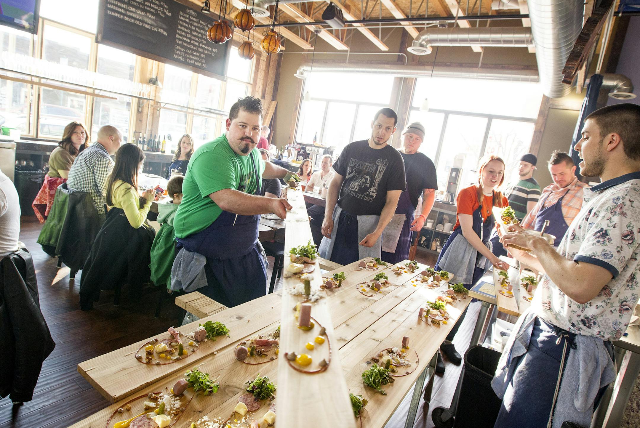 Co-owner and chef Mike Brown passes a charcuterie board to another chef for service to a table at Travail in Robbinsdale in 2014.