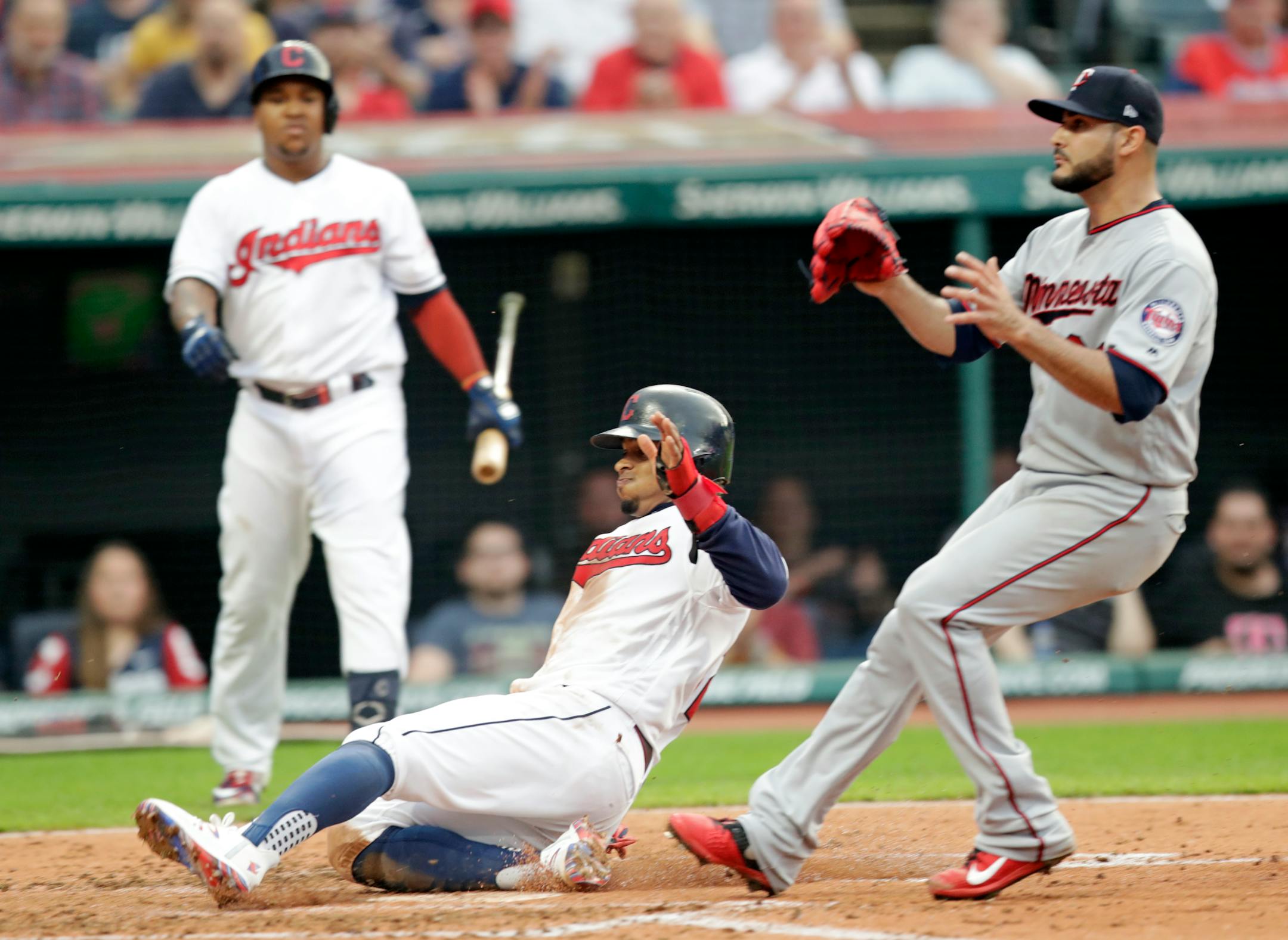 Cleveland's Francisco Lindor, center, scores on a passed ball by Twins catcher Jason Castro in the third inning
