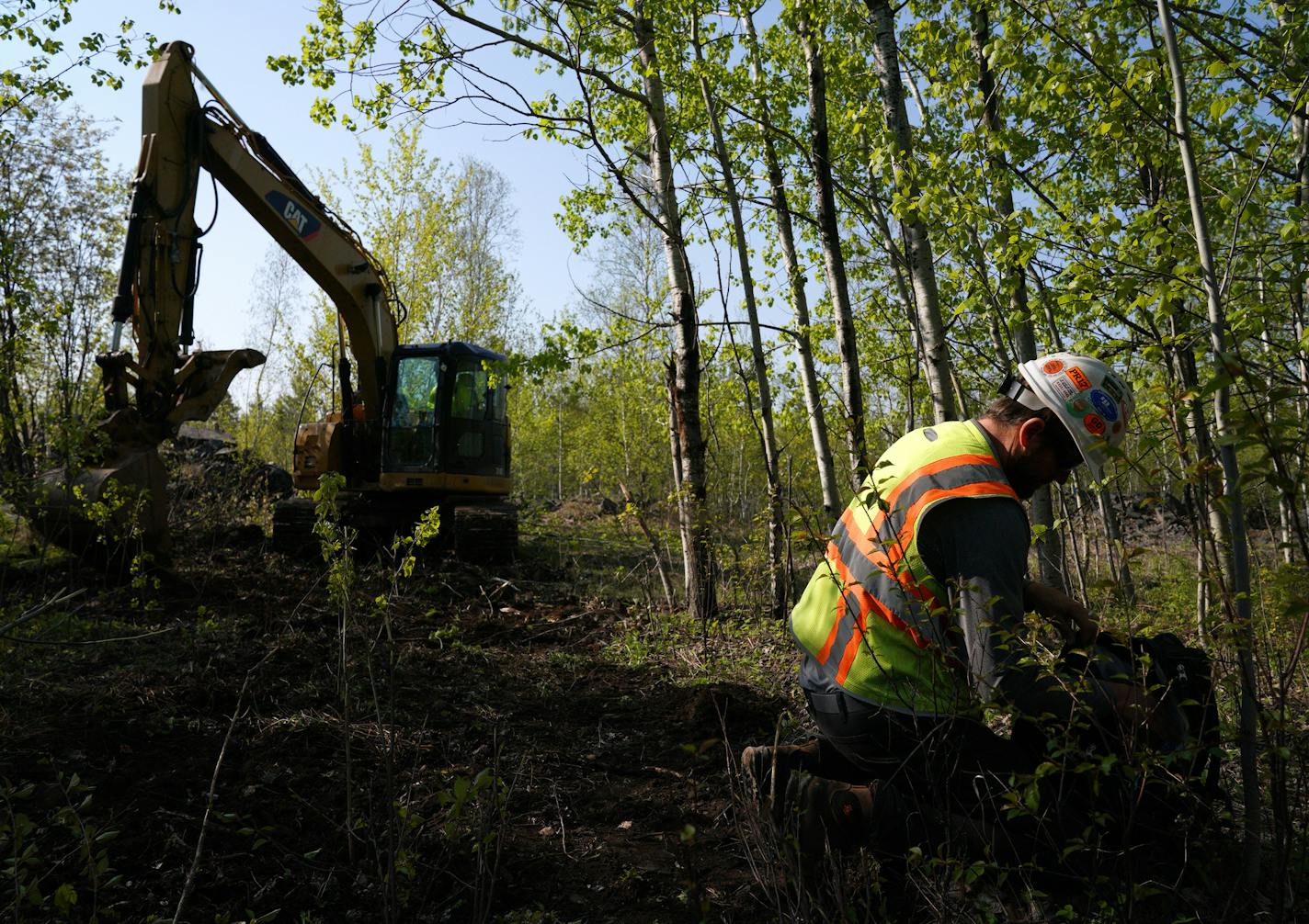 Eric Olson, right, gathered his tools as contractor Robert Radotich used a backhoe to dig areas so the soil stratification can be observed which will help them engineer and design the infiltration pods. ] ANTHONY SOUFFLE &#x2022; anthony.souffle@startribune.com Jon Cherry, President, CEO and Director at Polymet, Bruce Richardson, Vice President of Corporate Communications and External Affairs, and LaTisha Gietzen, Vice-President of Public, Government, and Environmental Affairs, gave a tour of th