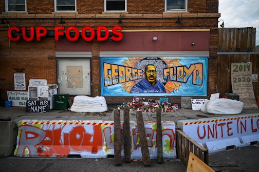 Newly installed concrete barriers surrounded the artwork and memorials outside Cup Foods.