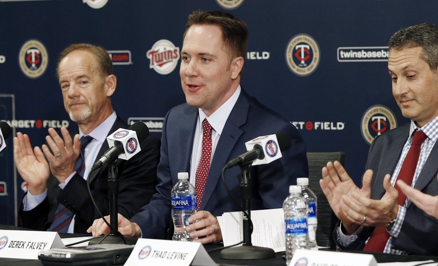 Minnesota Twins owner, Jim Pohlad, left, and new general manager Tad Levine, right, applaud the introduction of new chief baseball officer Derek Falvey, center, during introductions Monday, Nov. 7, 2016 in Minneapolis. (AP Photo/Jim Mone) ORG XMIT: MIN2016111122491956