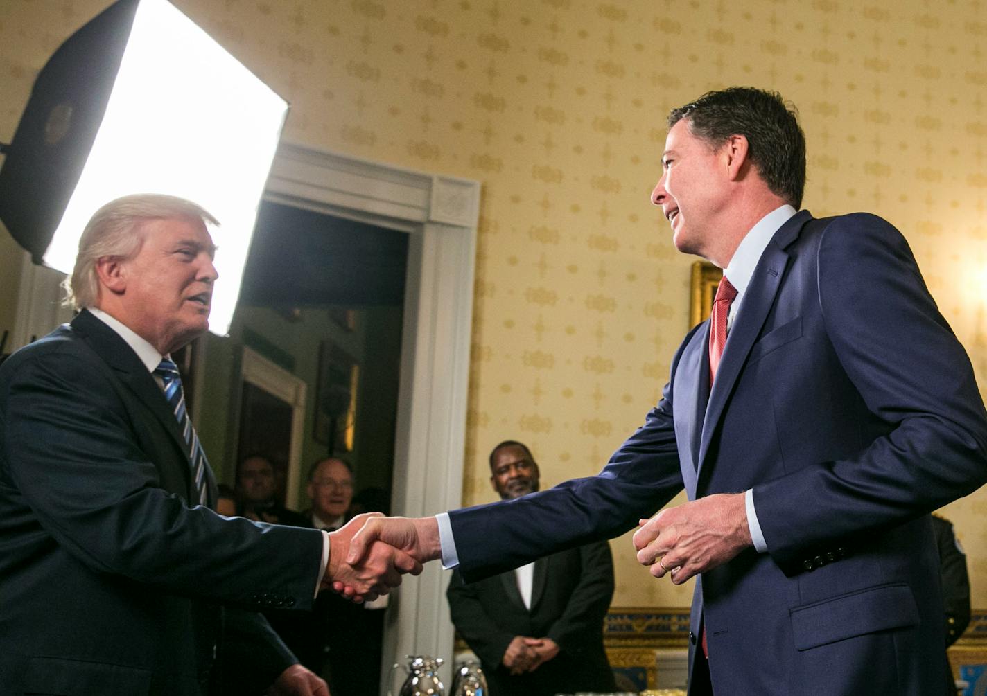 President Donald Trump and then-FBI Director James Comey shake hands in the Oval Office at a gathering of law enforcement officials in January 2016.