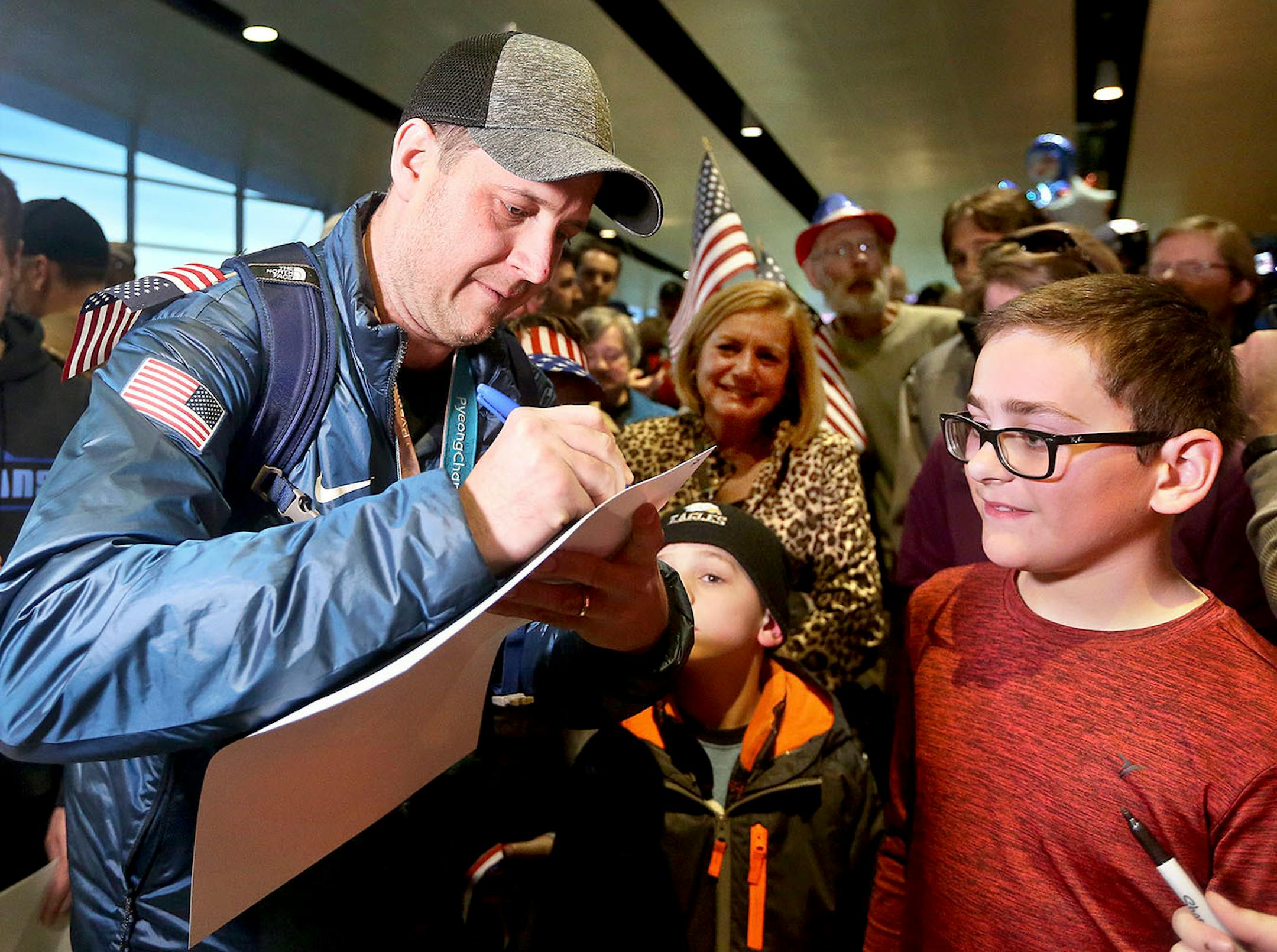 Trenton Bonin of Duluth gets a picture autographed by John Shuster. Bob King / rking@duluthnews.com