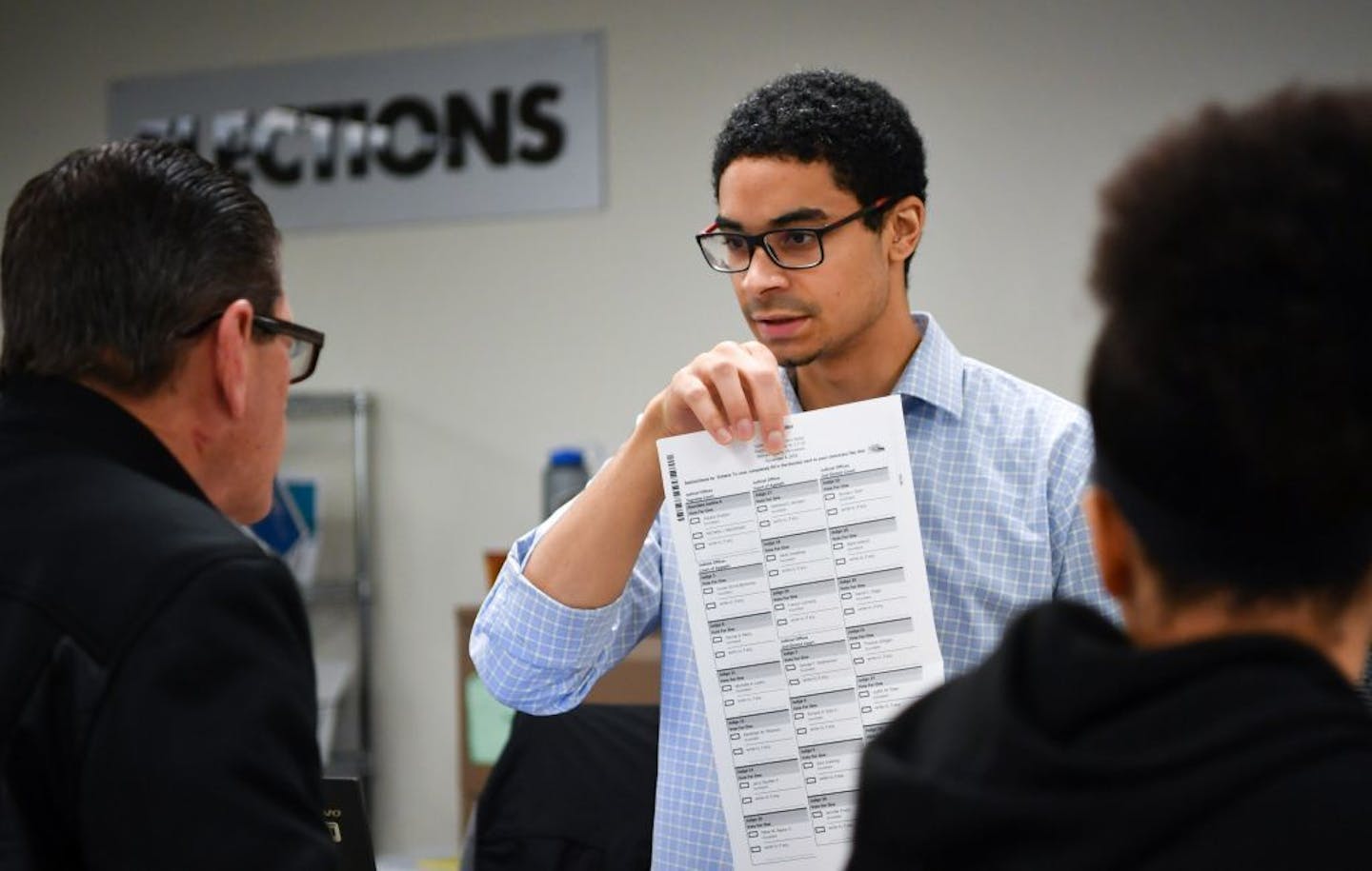 Election assistant Shane McSparrow explained the voting procedure to a voter on the last day of early voting in St. Paul.