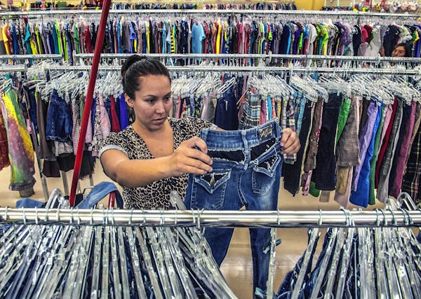 A woman shops for used clothing at a Savers thrift store.