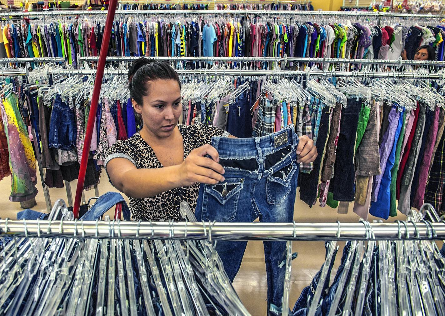 A woman shops for used clothing at a Savers thrift store.