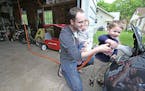 Tyler Sahnow gave his son Ethan, 3, a lesson in plugging in the Nissan Leaf from the EV charging station, Wednesday, May 20, 2015 in Minneapolis, MN. 