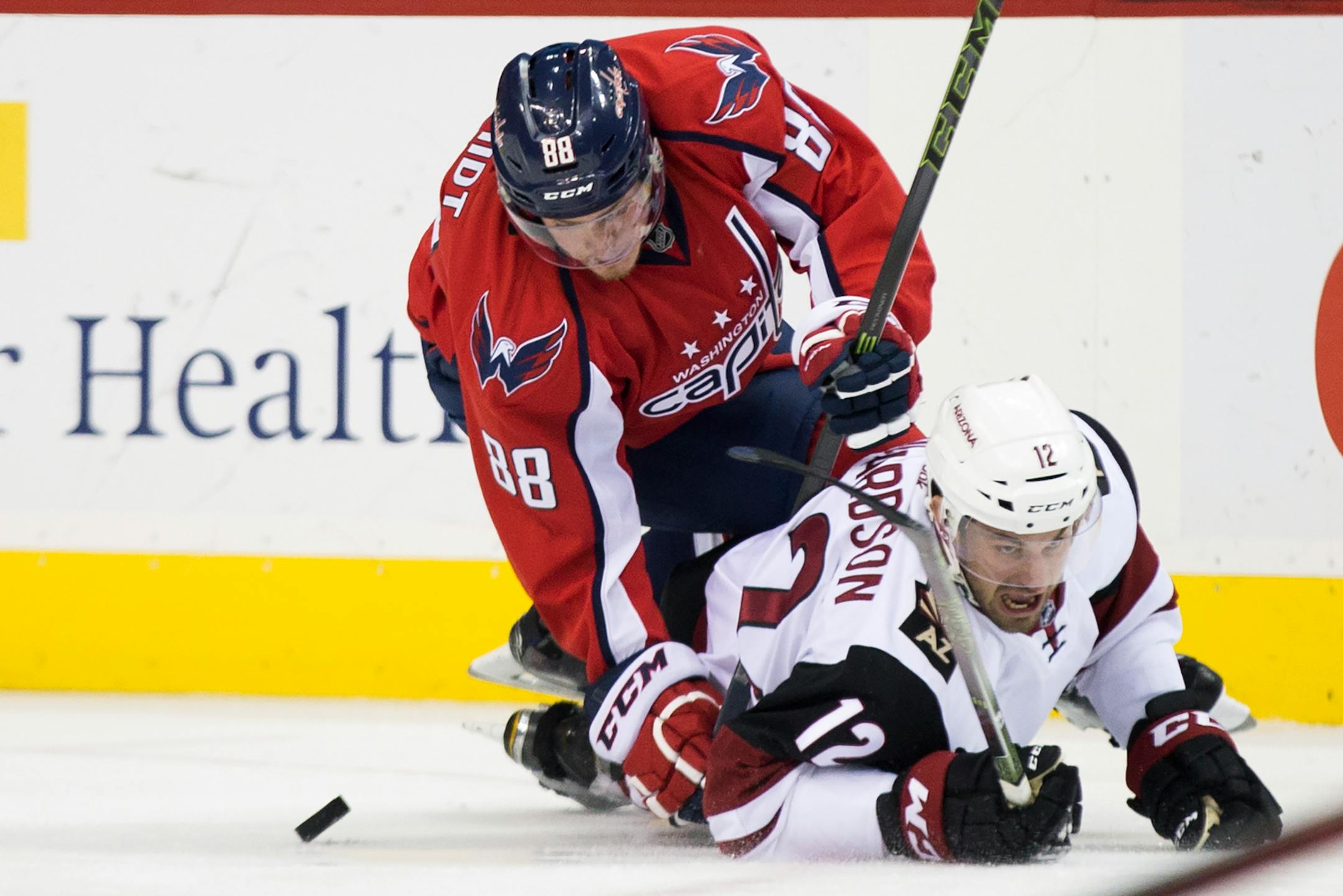 Washington Capitals defenseman Nate Schmidt (88) and Arizona Coyotes center Brad Richardson (12) fight for the puck during the first period of an NHL hockey game, on Monday, Feb. 22, 2016, in Washington. (AP Photo/Evan Vucci)