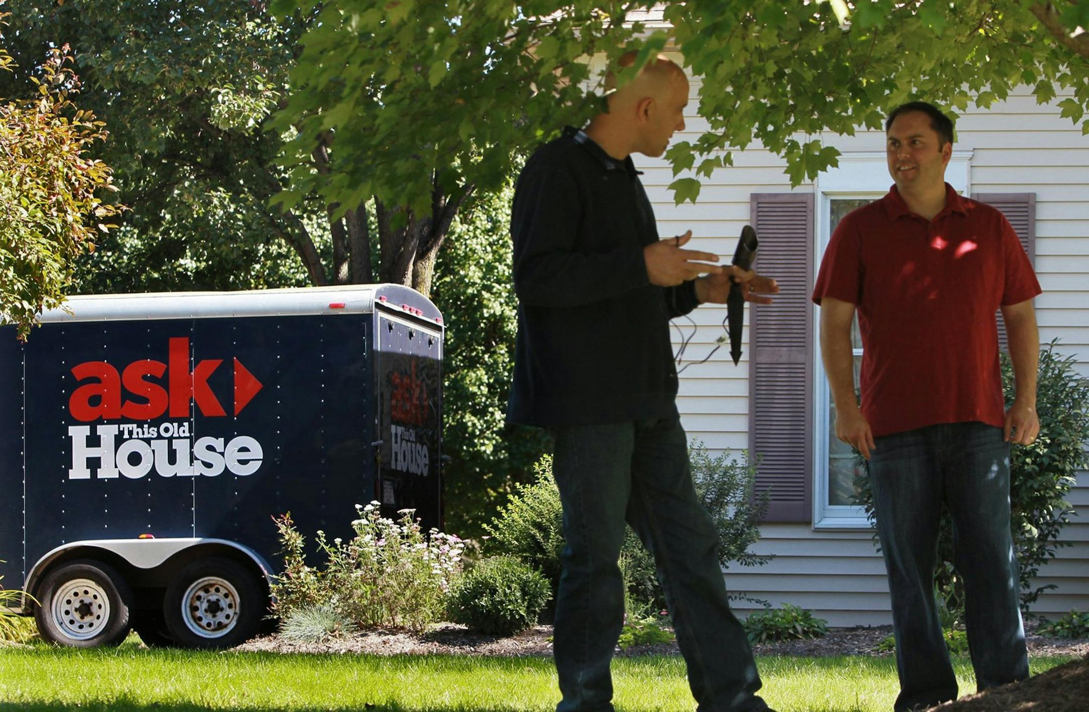 Scott Caron, left, the talent and an electrician on “Ask This Old House,” explained to homeowner Steve Fening how they would illuminate a tree in his lawn as part of the exterior lighting project completed while taping an episode of the show.