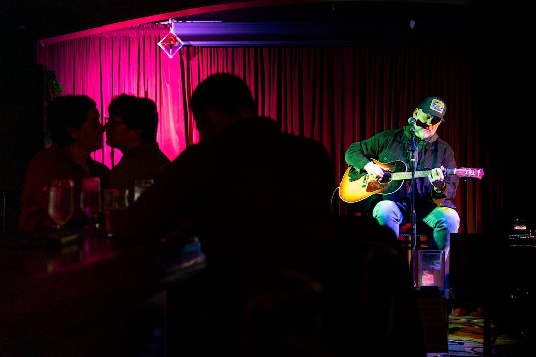 Singer-songwriter Tony Cuchetti performed at the Mudd Room while a couple kisses in Mendota. The 1920’s-inspired speakeasy lies below Lucky’s 13 Pub and offers live music and craft cocktails and food.