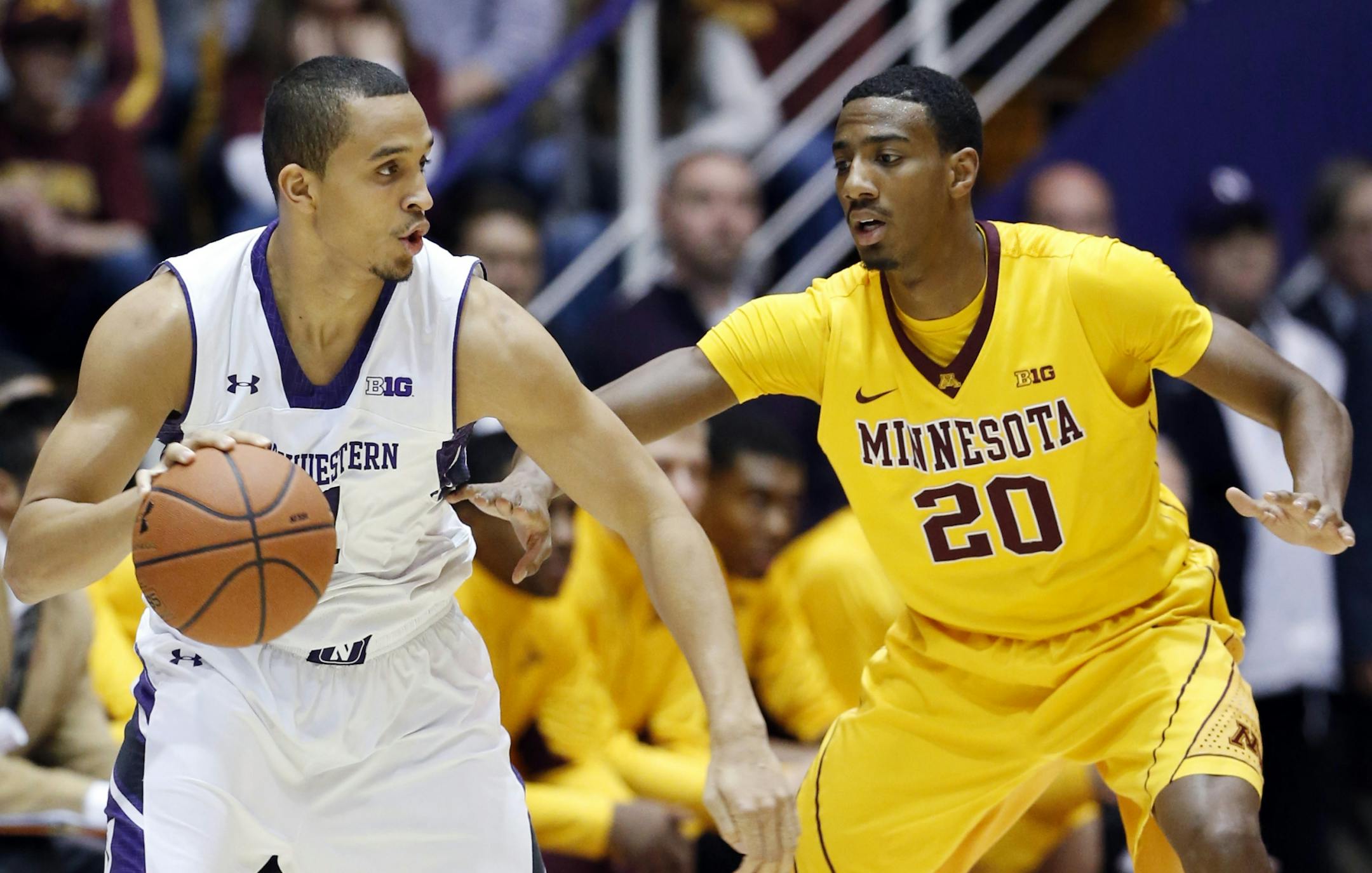 Northwestern guard Reggie Hearn, left, looks to pass against Minnesota guard Austin Hollins on Wednesday night,