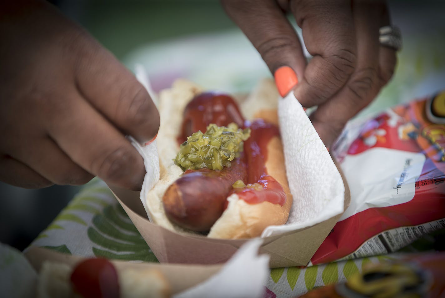 Thirteen-year-old hot dog entrepreneur Jaequan Faulkner served up a hot dog meals to Yvonne Ross and her son Drameris Ross, 7, at his hot dog stand, Monday, July 16, 2018 in Minneapolis, MN. ELIZABETH FLORES ï liz.flores@startribune.com