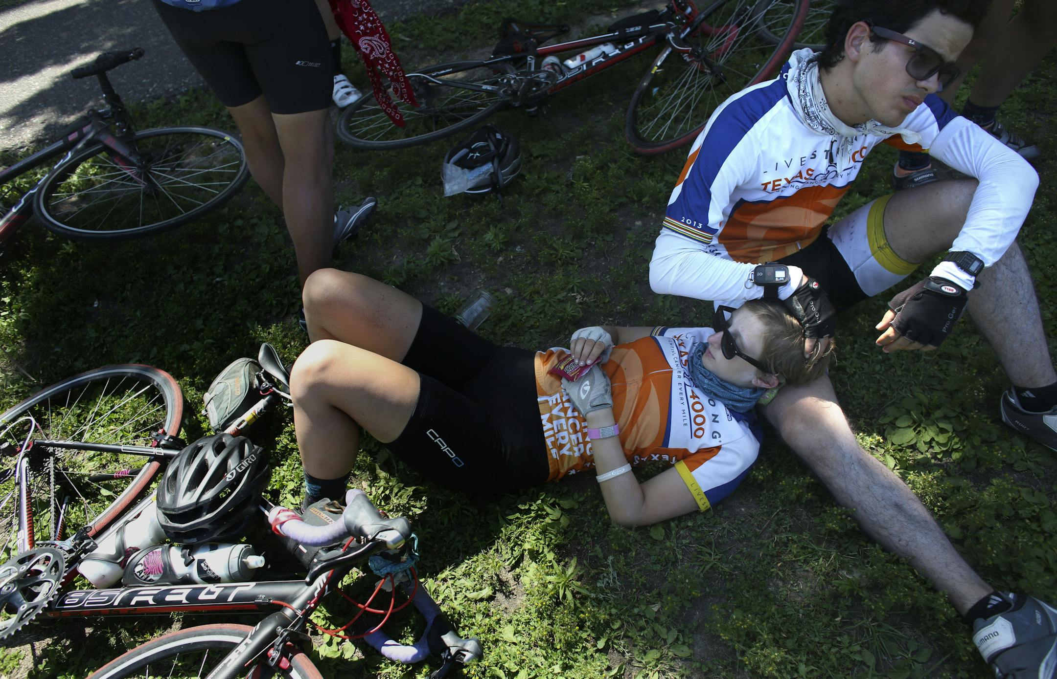 University of Texas student Ashley Day rested on fellow student, Diego Farias as they took a break from their trek from Austin, Texas to Anchorage, Alaska on the grass lawn near the Stone Arch Bridge in Minneapolis Min., Wednesday, July 3, 2013. Sixty-nine students were participating in the annal Texas 4000 that was raising money for cancer. The trip is on day 33 of 70. ] (KYNDELL HARKNESS/STAR TRIBUNE) kyndell.harkness@startribune.com