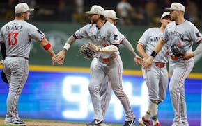 Twins players congratulate one another Friday night after their 12th win in a row.
