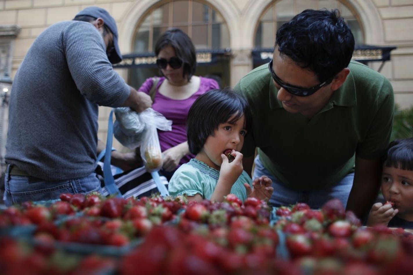 Victor Celadita encouraged daughter Amelia, 5, and son Victor, 2, to sample a strawberry at the farmers market on Nicollet Mall.