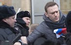 Russian opposition leader Alexei Navalny, centre, is detained by police officers in Moscow, Russia, Sunday, Jan. 28, 2018. Opposition politician Alexe