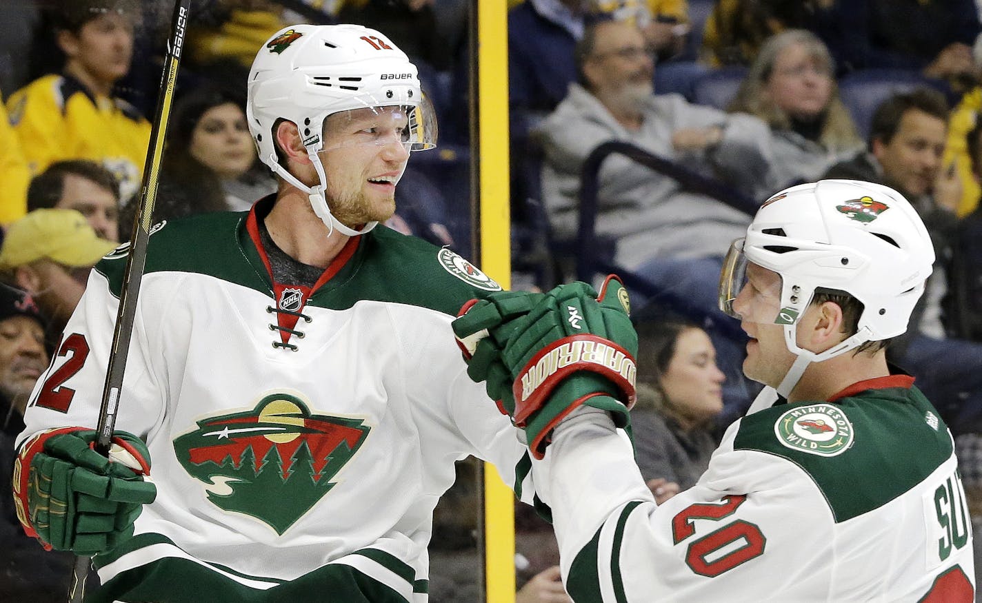 Minnesota Wild center Eric Staal (12) celebrates with Ryan Suter (20) after Staal scored a goal against the Nashville Predators during the first period of an NHL hockey game Thursday, Dec. 15, 2016, in Nashville, Tenn. (AP Photo/Mark Humphrey)