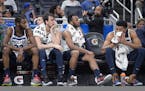 Andrew Wiggins (22), forward Dario Saric, second from left, guard Josh Okogie and center Karl-Anthony Towns, right, watch from the bench at the end of