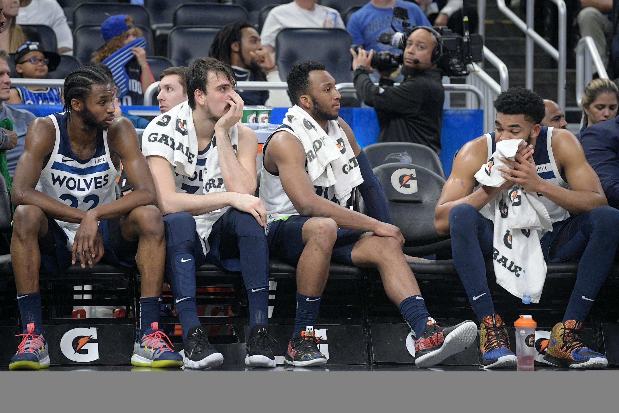 Andrew Wiggins (22), forward Dario Saric, second from left, guard Josh Okogie and center Karl-Anthony Towns, right, watch from the bench at the end of Thursday's loss.