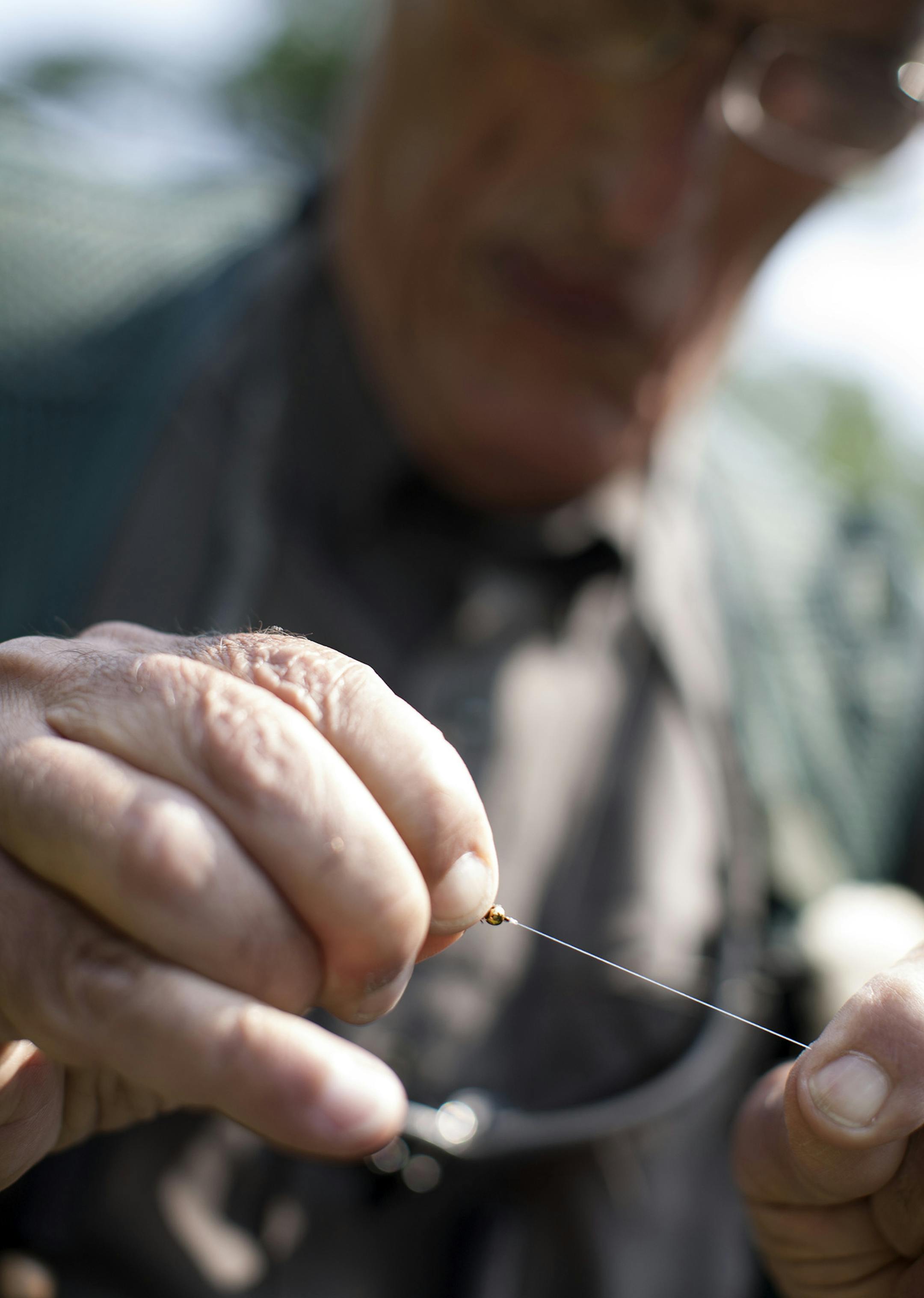 National Trout Center program coordinator Rich Enochs ties a fly before fishing in Trout Run Creek in Fillmore County in Southeast Minnesota July 10, 2014. (Courtney Perry/Special to the Star Tribune)