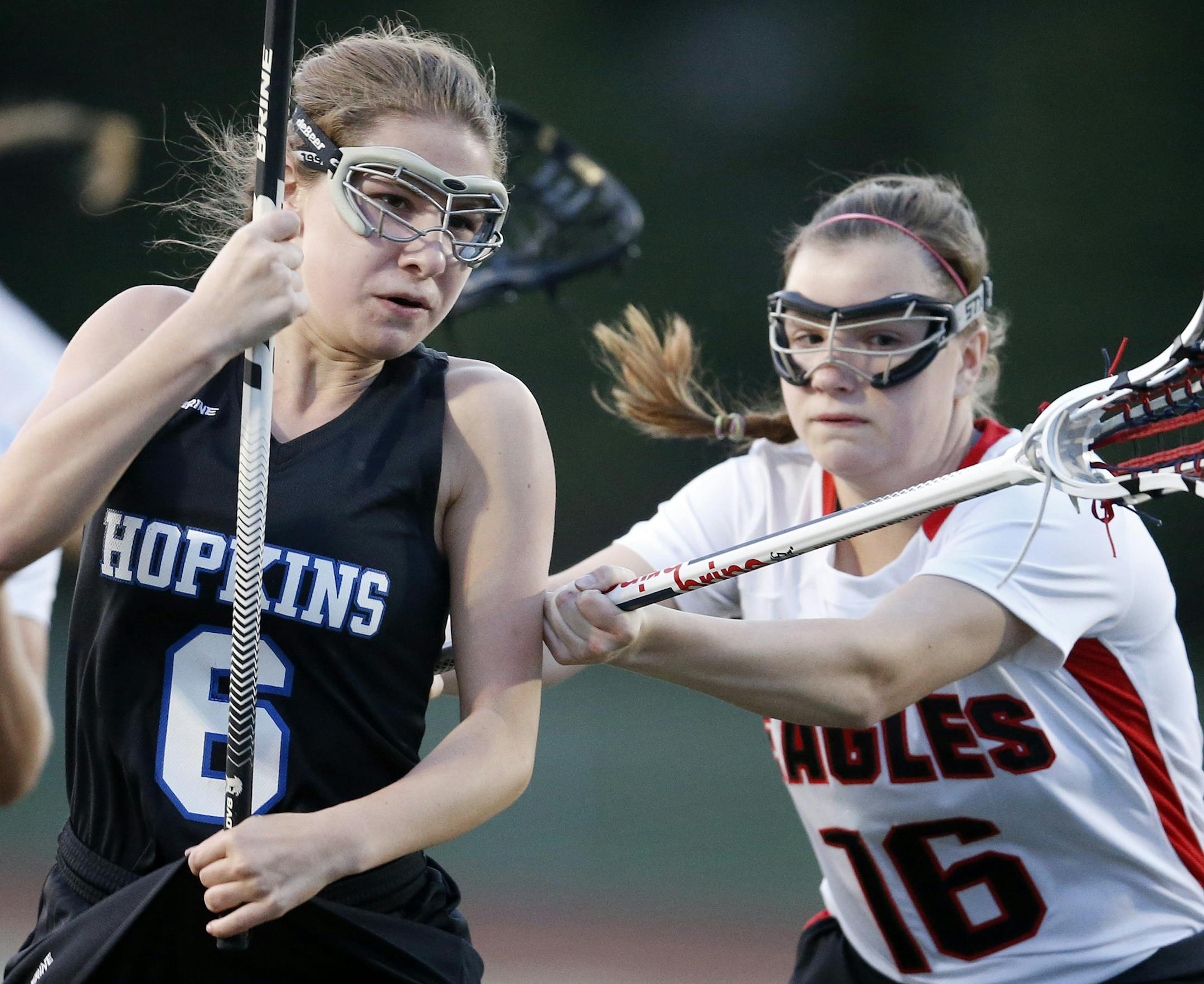 In Minnesota, girls' lacrosse players wear only eye protection, as seen here on Anna Guettler of Hopkins, left, and Hannah Brink of Eden Prairie.