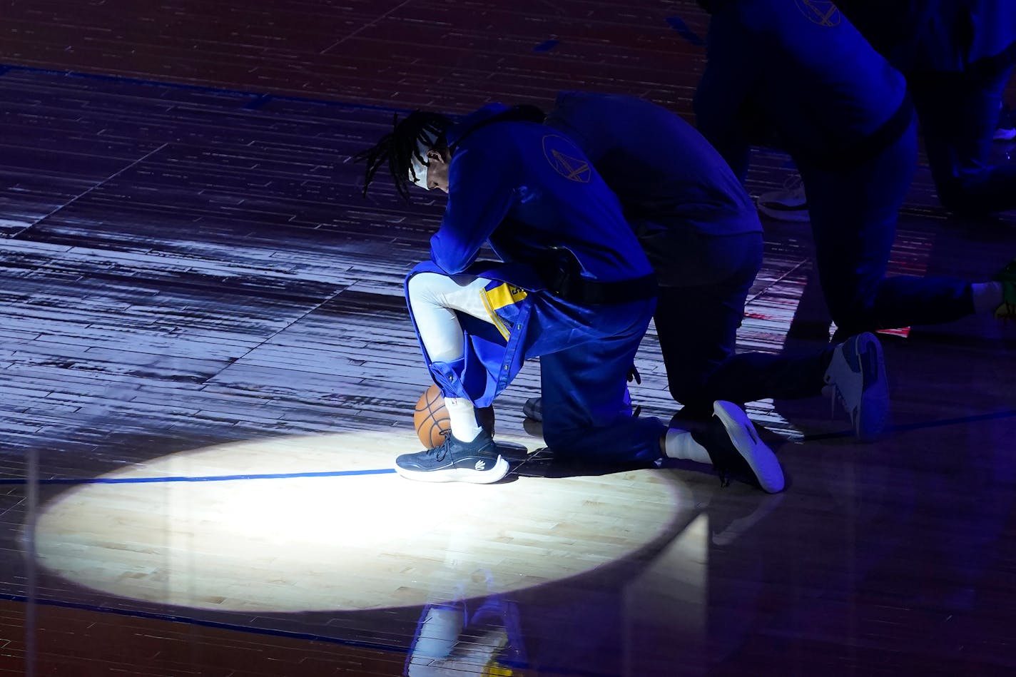 Golden State Warriors guard Damion Lee and teammates kneel during the national anthem before an NBA basketball game against the Los Angeles Clippers in San Francisco, Wednesday, Jan. 6, 2021. (AP Photo/Jeff Chiu)