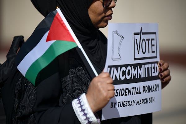 Semira Ibrahim of Apple Valley held a sign urging voters to vote uncommitted, at a news conference outside the federal courthouse in Minneapolis on Fe