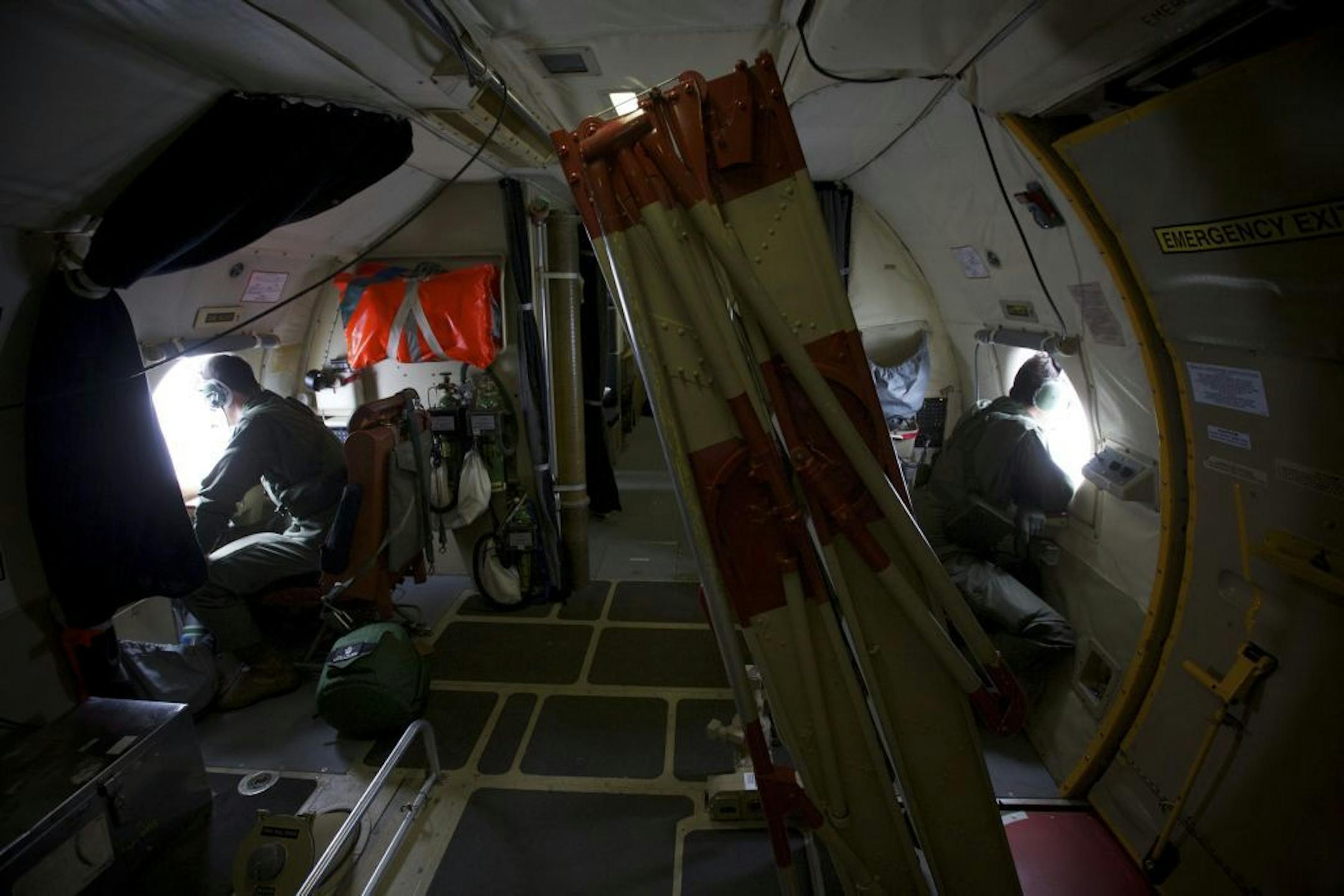 FILE - In this Monday, March 24, 2014 file photo, crewmen of an Royal Australian Air Force AP-3C Orion aircraft look out of their observation windows whilst searching for missing Malaysia Airlines Flight MH370 over the Indian Ocean.