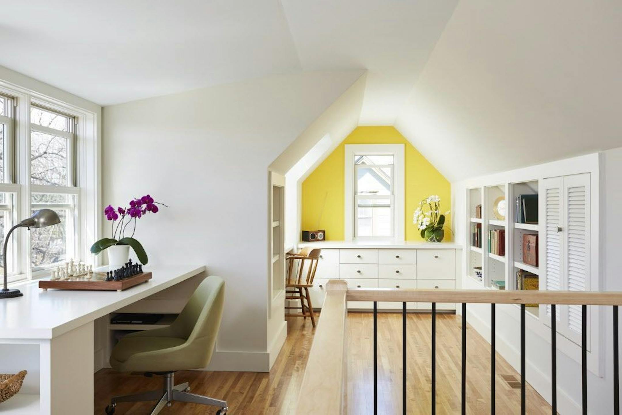 More windows, a skylight and built-in desks, bookshelves and file cabinets, provide lots of natural light and work layout space in the converted third-floor attic by Christopher Strom Architects.