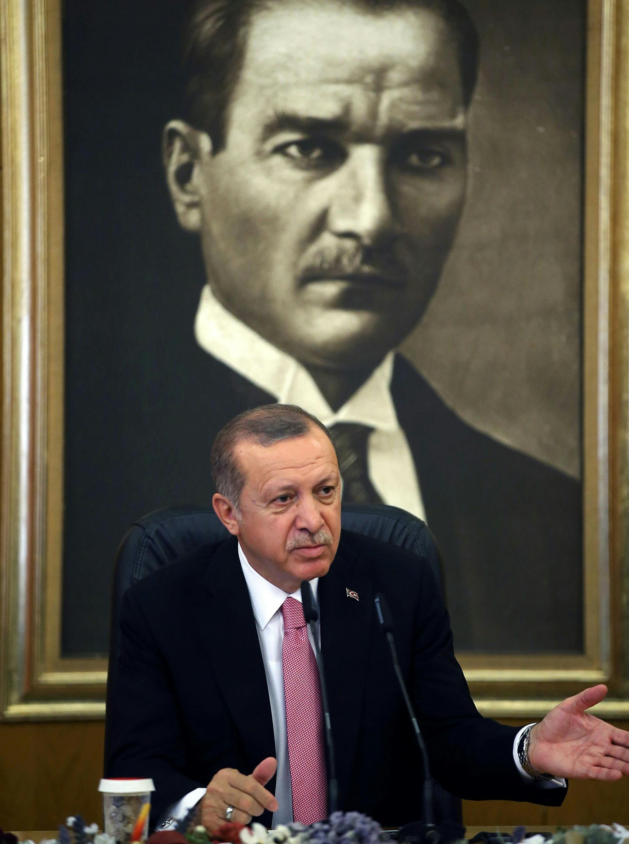 Backdropped by a picture of Mustafa Kemal Ataturk, the founder of modern Turkey, Turkey's President Recep Tayyip Erdogan talks to members of the media in Istanbul, Friday, Sept. 8, 2017. Erdogan on Friday slammed the United States over charges that a former Turkish economy minister conspired to help Iran evade U.S. sanctions. (Presidency Press Service, Pool photo via AP) ORG XMIT: XLP102