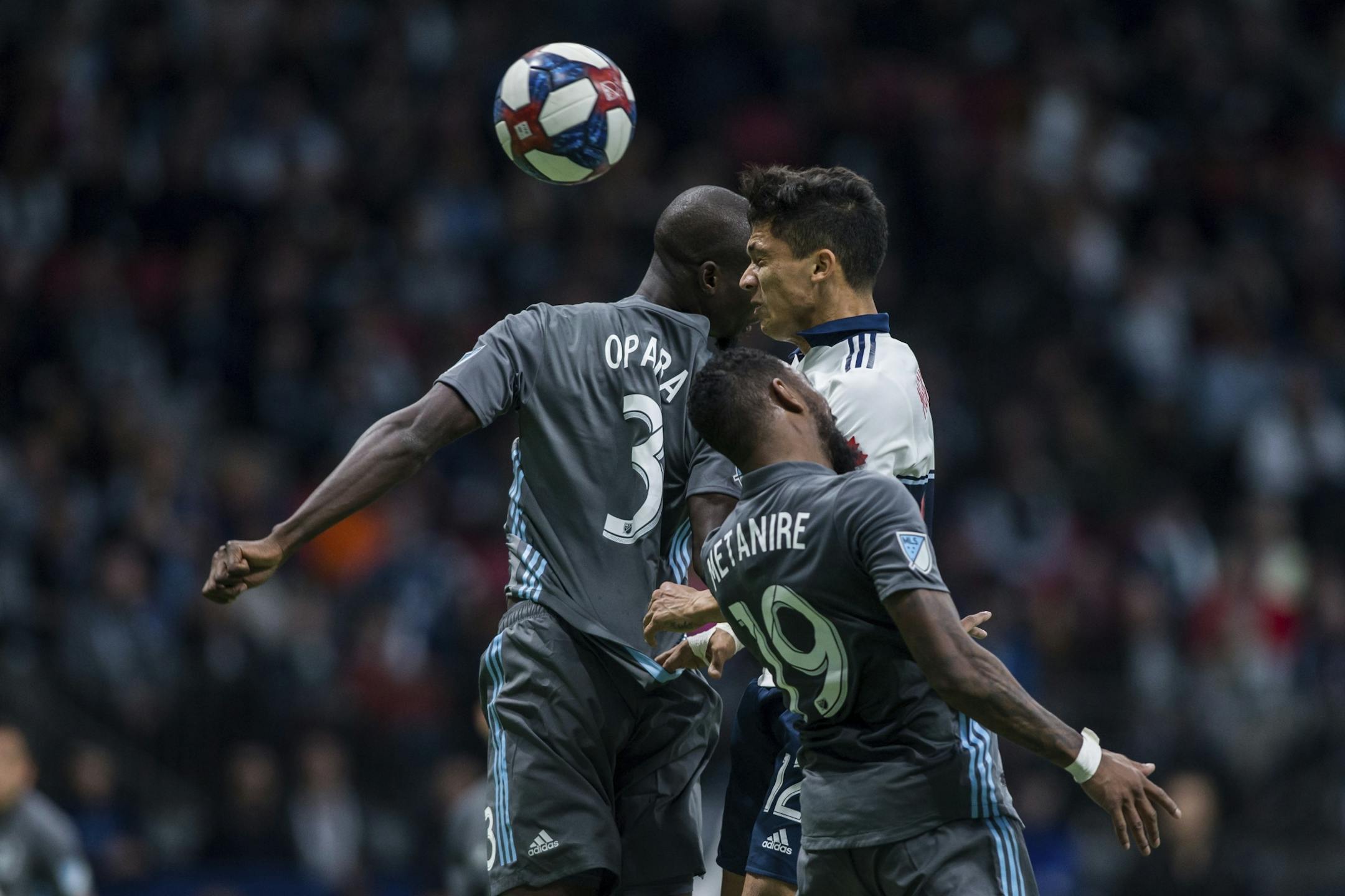 Vancouver Whitecaps' Fredy Montero (12) heads the ball against Minnesota United's Ike Opara (3) and Romain Metanire (19) during the second half of an MLS soccer match Saturday, March 2, 2019, in Vancouver, British Columbia.
