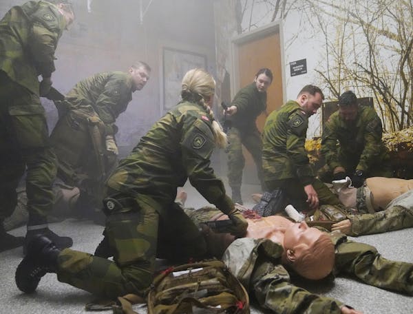 Norwegian Home Guard member Pvt. Henrikke Iversen, center, works with fellow Home Guard members during training on combat lifesaving techniques from m