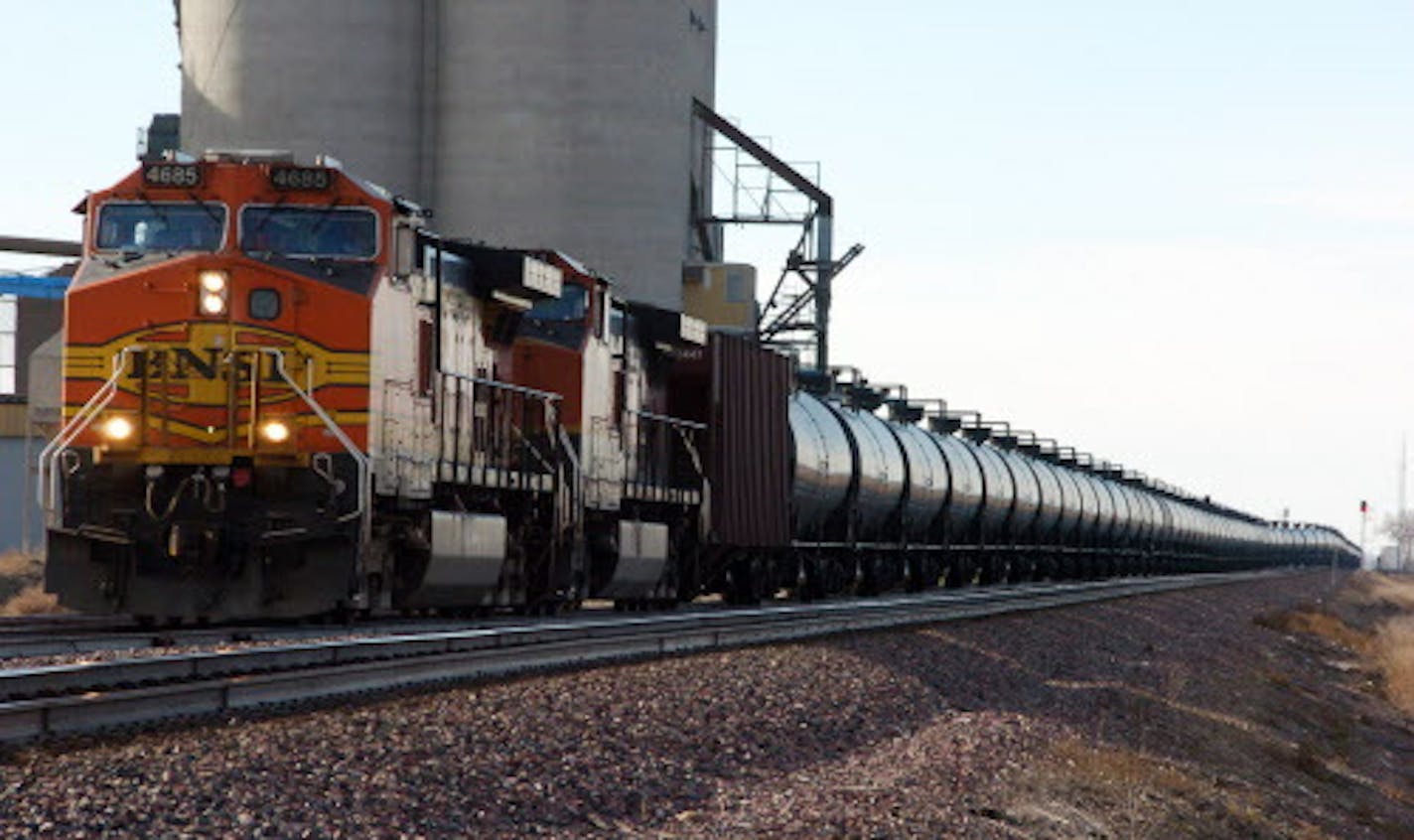 FILE - This Nov. 6, 2013, file photo shows a BNSF Railway train hauling crude oil near Wolf Point, Mont. Thousands of older rail tank cars that carry crude oil would be phased out within two years under regulations proposed in response to a series of fiery train crashes over the past year. Transportation Secretary Anthony Foxx said the government's testing of crude oil from the Bakken region of North Dakota and Montana shows the oil is on the high end of a range of volatility compared with other