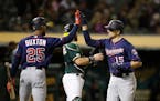 Minnesota Twins' Jason Castro, right, celebrates with Byron Buxton (25) after hitting a home run off Oakland Athletics' Yusmeiro Petit during the seve