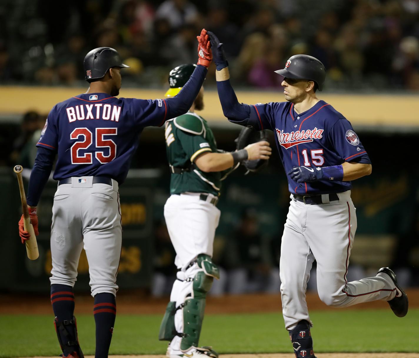 Minnesota Twins' Jason Castro, right, celebrates with Byron Buxton (25) after hitting a home run off Oakland Athletics' Yusmeiro Petit during the seventh inning of a baseball game Tuesday, July 2, 2019, in Oakland, Calif. (AP Photo/Ben Margot)