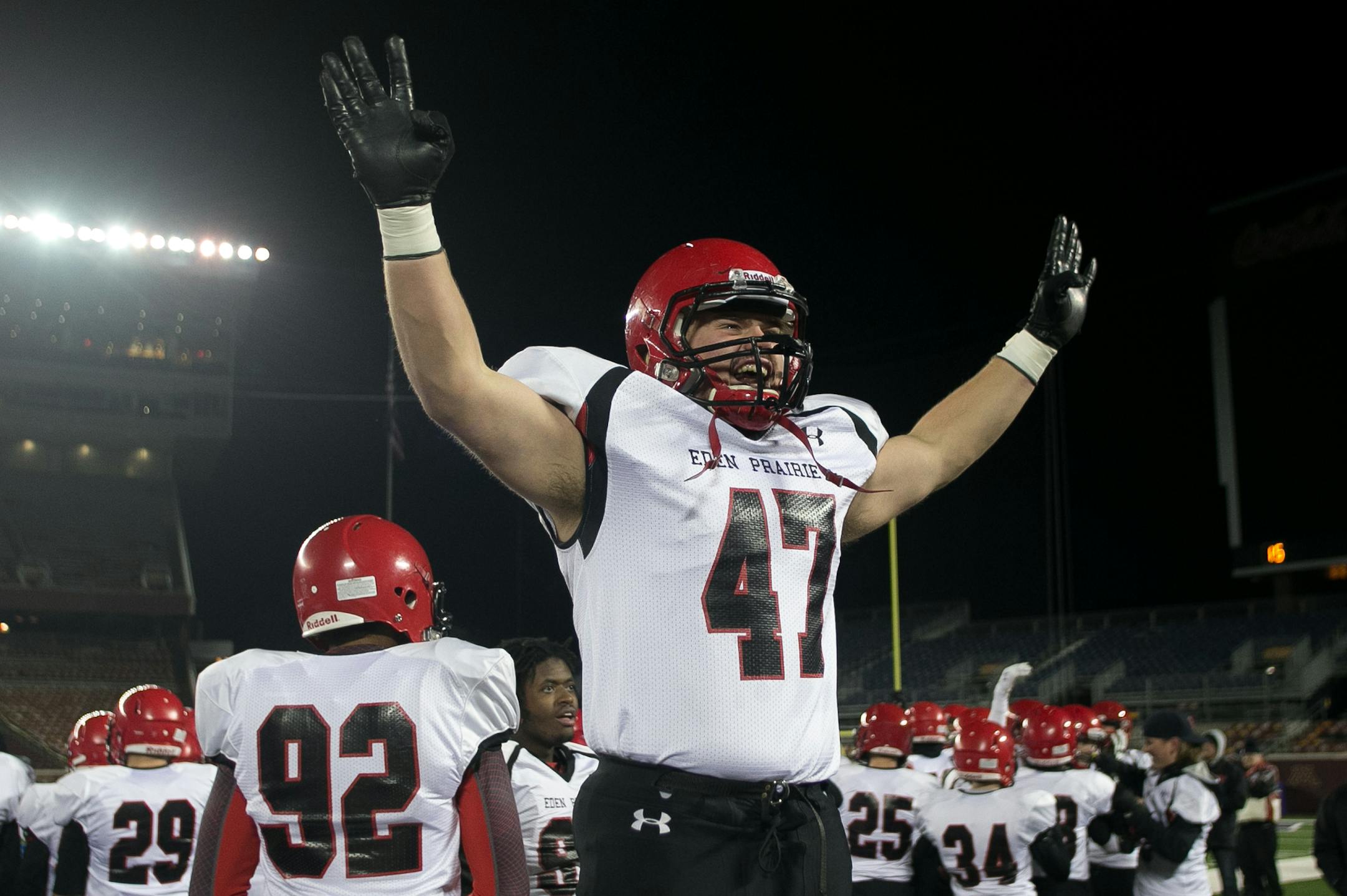 Eden Prairie defensive end Jake Halvarson puts up his hands with four fingers to represent his team's fourth title in a row to the student section Friday night. ] AARON LAVINSKY • aaron.lavinsky@startribune.com Totino-Grace takes on Eden Prairie in the Class 6A Prep Bowl Friday, Nov. 21, 2014 at TCF Bank Stadium.
