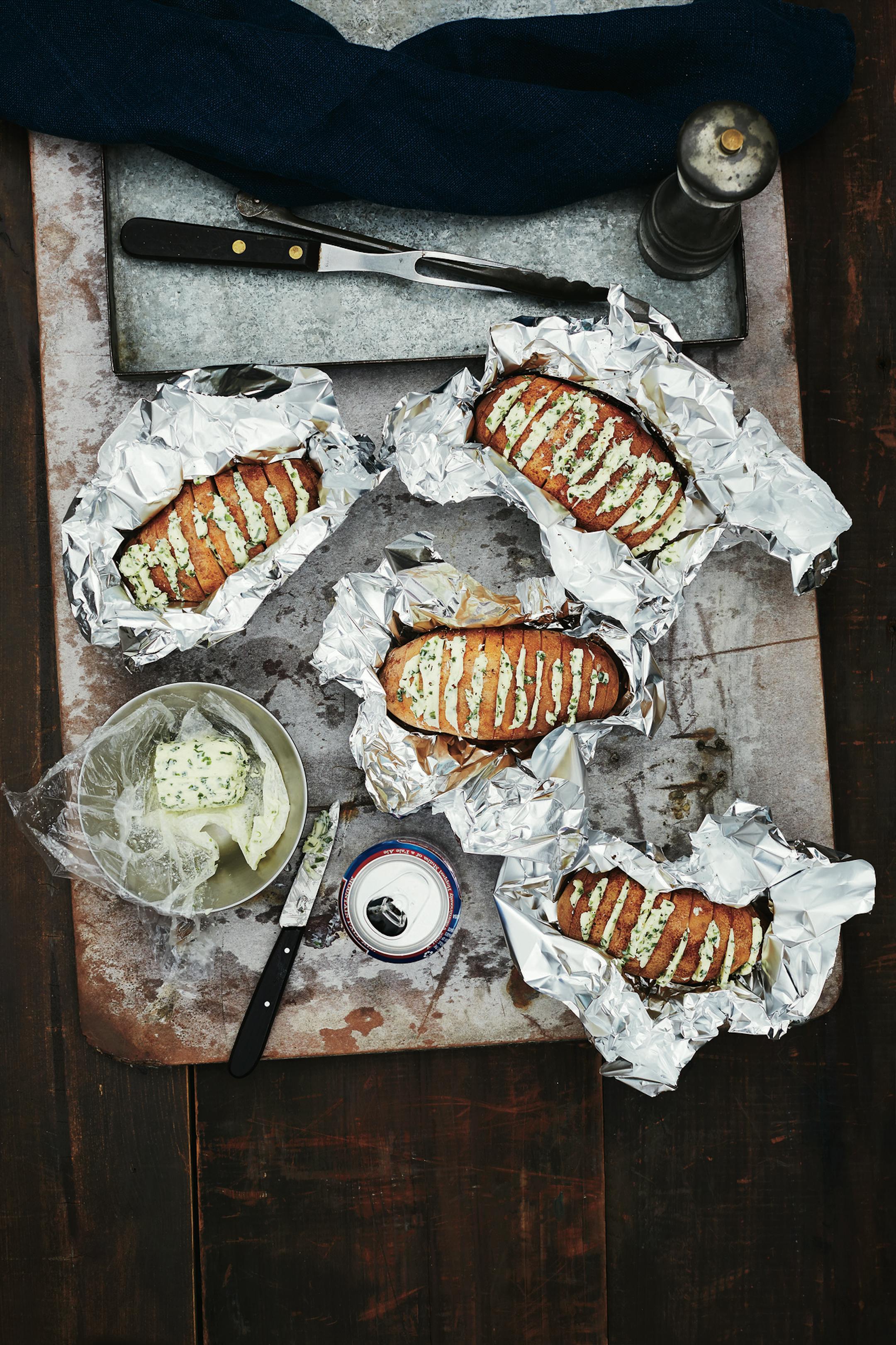 Grilled Baked Potatoes with Chive Butter. From "Dinner Special" by the Editors of FOOD & WINE. Copyright © 2018 Oxmoor House. Reprinted with permission from Time Inc. Books, a division of Meredith Corporation. Photo by Marcus Nilsson ORG XMIT: Grilling with Tom Mylan
June201