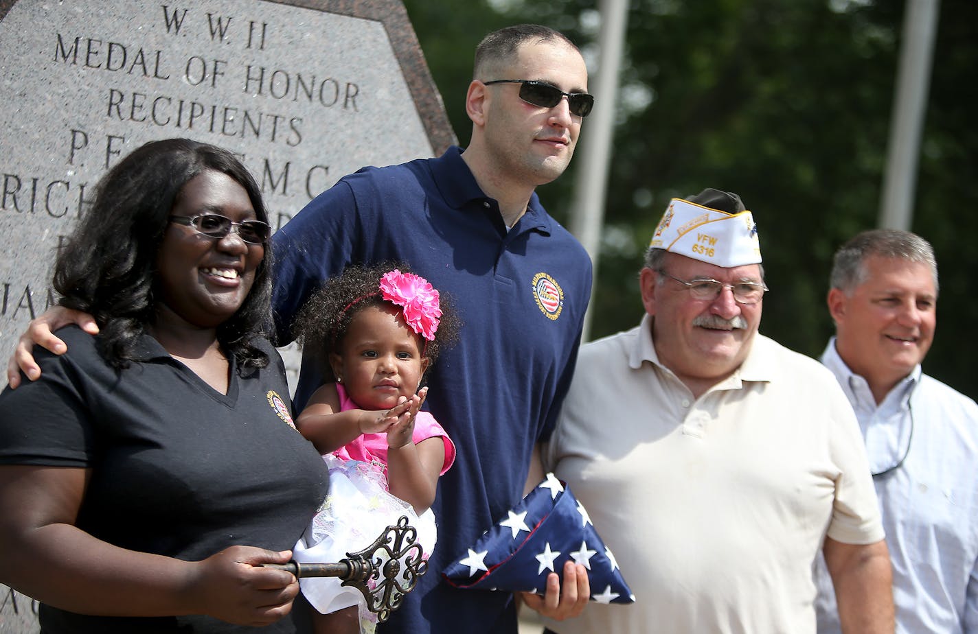 Afghanistan veteran Jason Smith and his wife Trizer Smith and their daughter Imani, 15 months, posed for photos as they participated in a ceremony where they were given a house Thursday, June 26, 2014 in Blaine, MN. Smith was given the key at the Veterans Memorial Park within Bunker Hills Park. The newly renovated mortgage-free home was provided by Chase Bank, AT&T, and the Military Warriors Support Foundation. ] (ELIZABETH FLORES/STAR TRIBUNE) ELIZABETH FLORES &#x2022; eflores@startribune.com