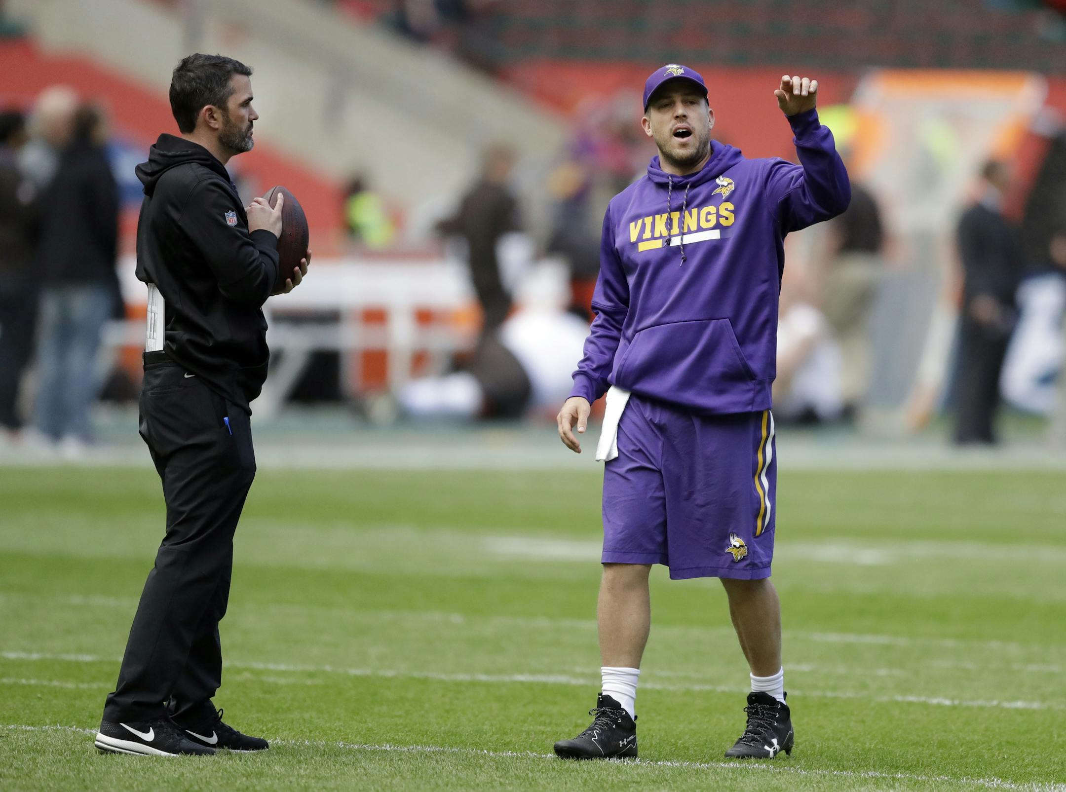 Minnesota Vikings quarterback Case Keenum, right, speaks with quarterbacks coach Kevin Stefanski while warming up before an NFL football game against Cleveland Browns at Twickenham Stadium in London, Sunday Oct. 29, 2017.