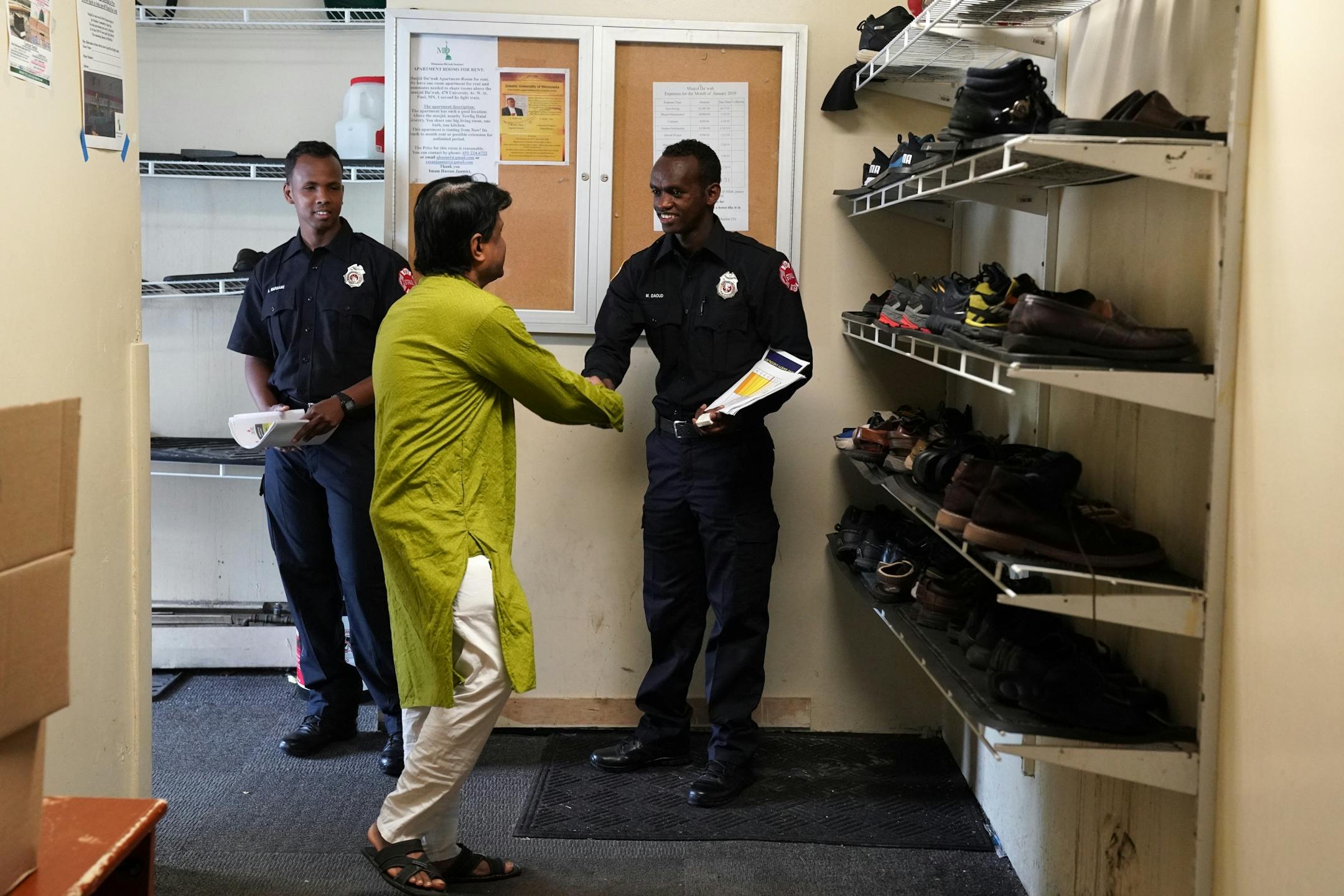 Abdi Warsame and Mohamed Daoud , two newly sworn in Somali American firefighters with the St. Paul Fire Department, greeted worshipers at the Islamic Dawah Center as part of their community outreach.
