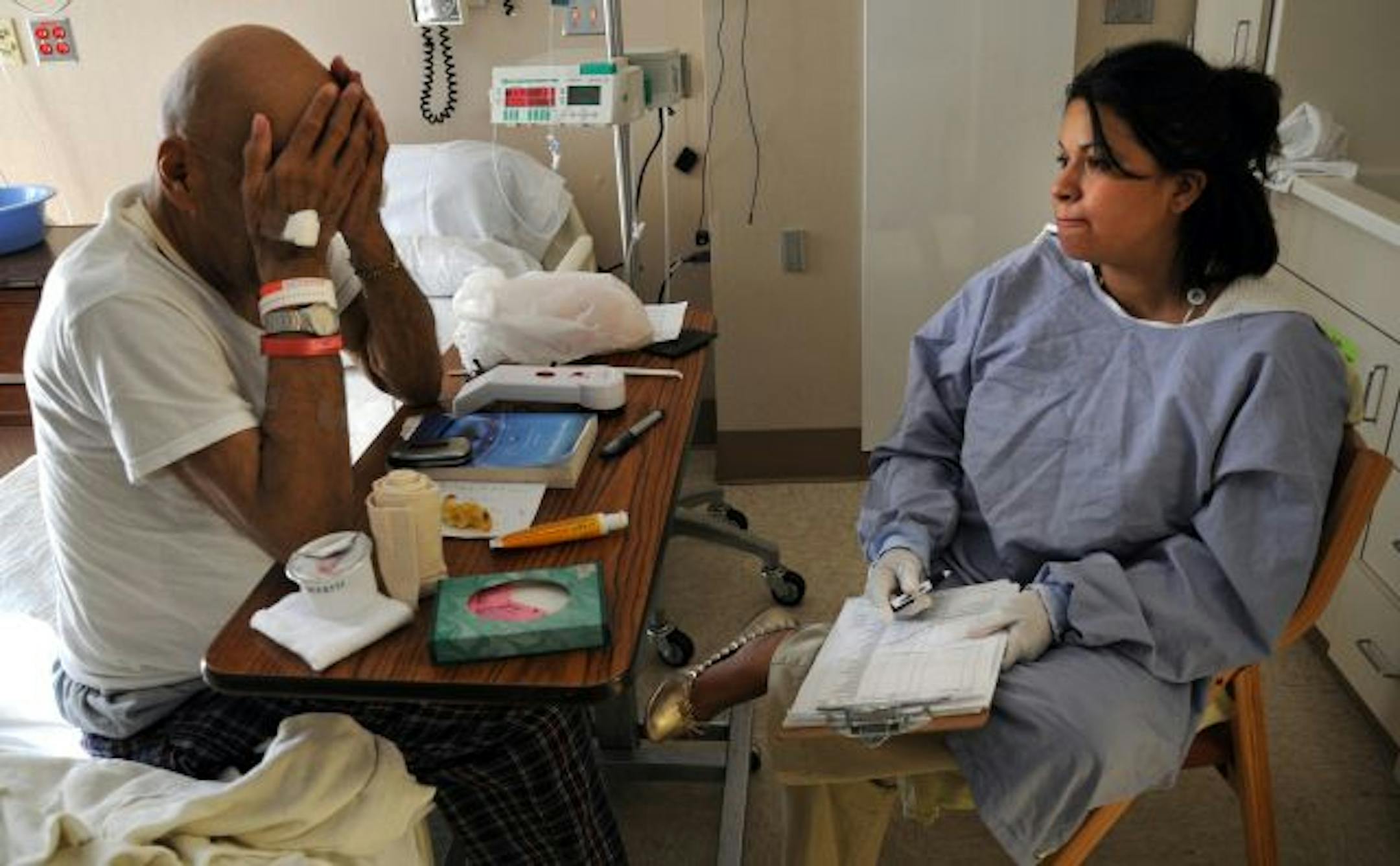 Aida Winona Strom talked with heart patient Glenn Greene from the Leech Lake Reservation about arranging for personal care when he leaves the hospital.