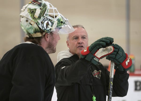 Minnesota Wild coach Dean Evason talks with goalie Devan Dubnyk before practice started at the NHL hockey team's training camp Monday, July 13, 2020, 