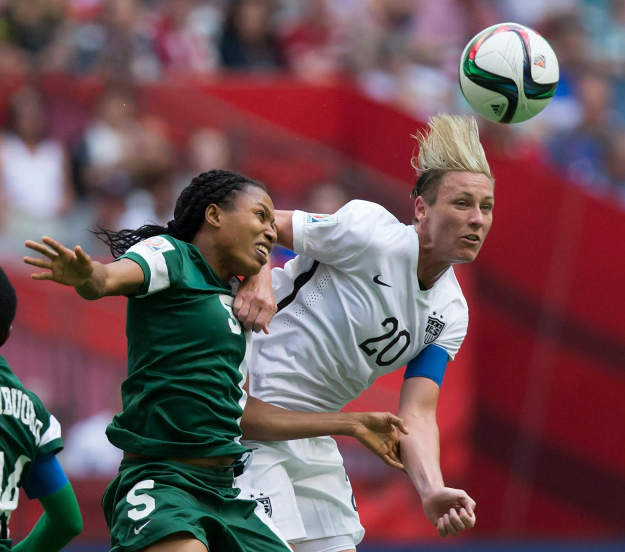 Nigeria's Onome Ebi, left, and United States' Abby Wambach vie for the ball during the second half of a FIFA Women's World Cup soccer game Tuesday, June 16, 2105, in Vancouver, British Columbia, Canada. (Darryl Dyck/The Canadian Press via AP) ORG XMIT: VCRD147