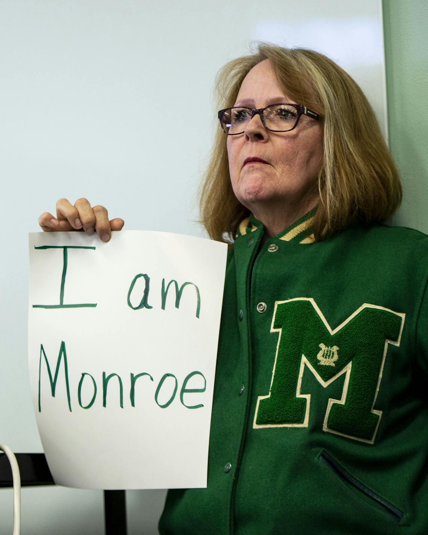 Joan Del Rio, Monroe High School class of 1976, holds a sign in protest against the proposed name change of the Linwood Monroe Arts Plus school to Global Arts Plus. ] NICOLE NERI &#x2022; nicole.neri@startribune.com BACKGROUND INFORMATION: A proposal to rename Linwood Monroe Arts Plus to Global Arts Plus is discusses at an Independent School District 165 meeting at the administration building Tuesday, June 18, 2019