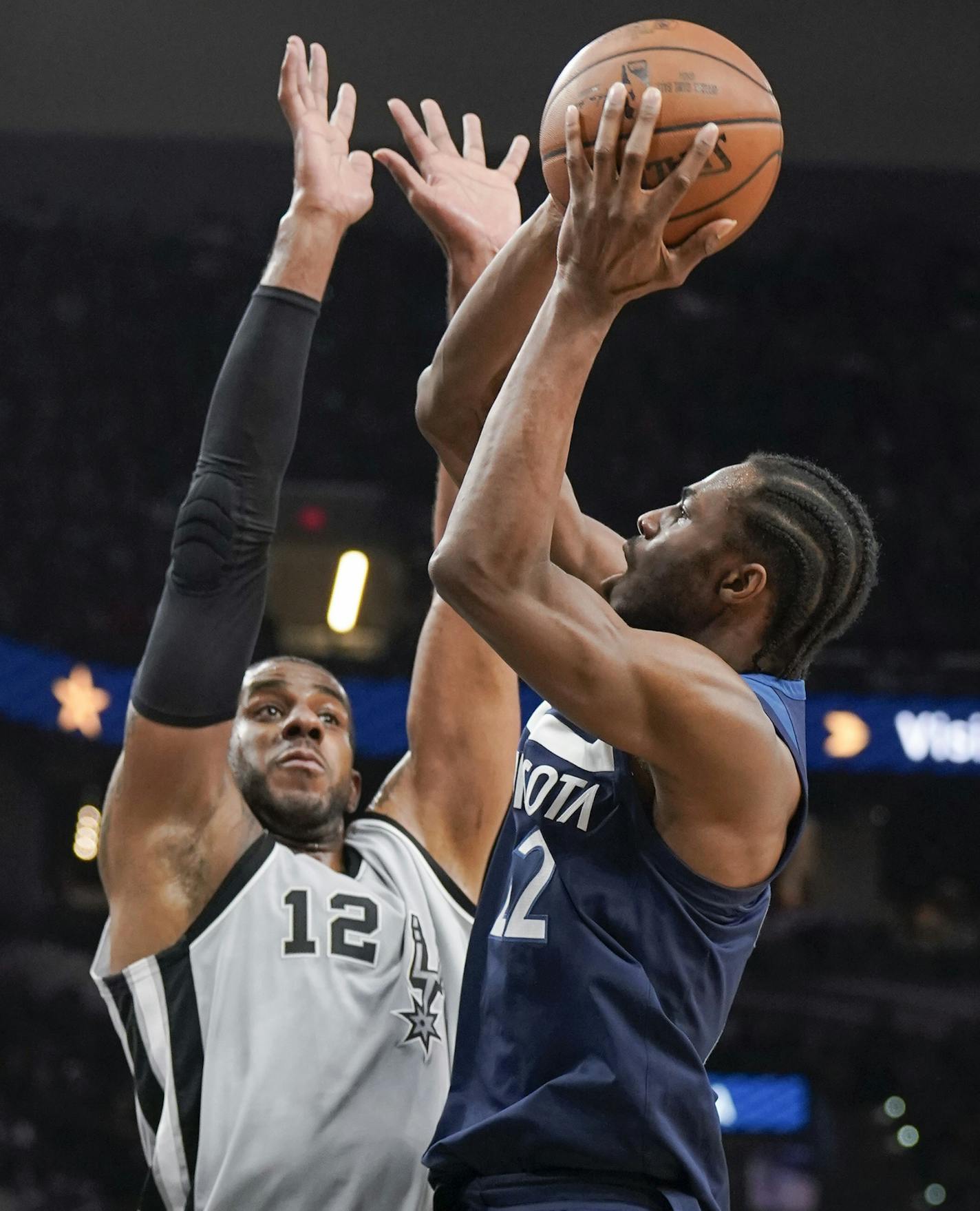 Minnesota Timberwolves' Andrew Wiggins, right, shoots against San Antonio Spurs' LaMarcus Aldridge during the first half of an NBA basketball game, Saturday, March 17, 2018, in San Antonio. (AP Photo/Darren Abate)