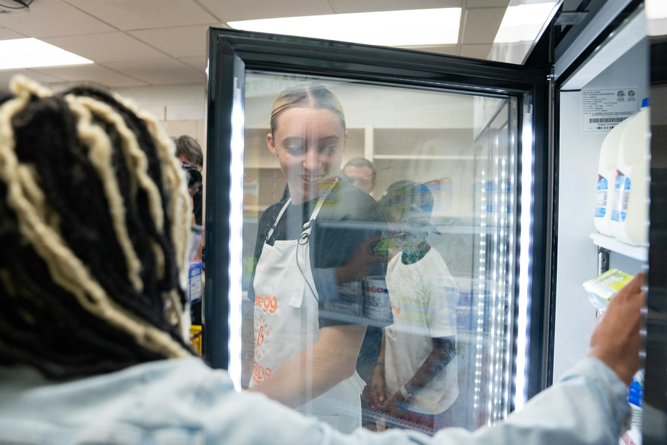Paige Bueckers walks and talks with students during the grand opening of a new free grocery store.
