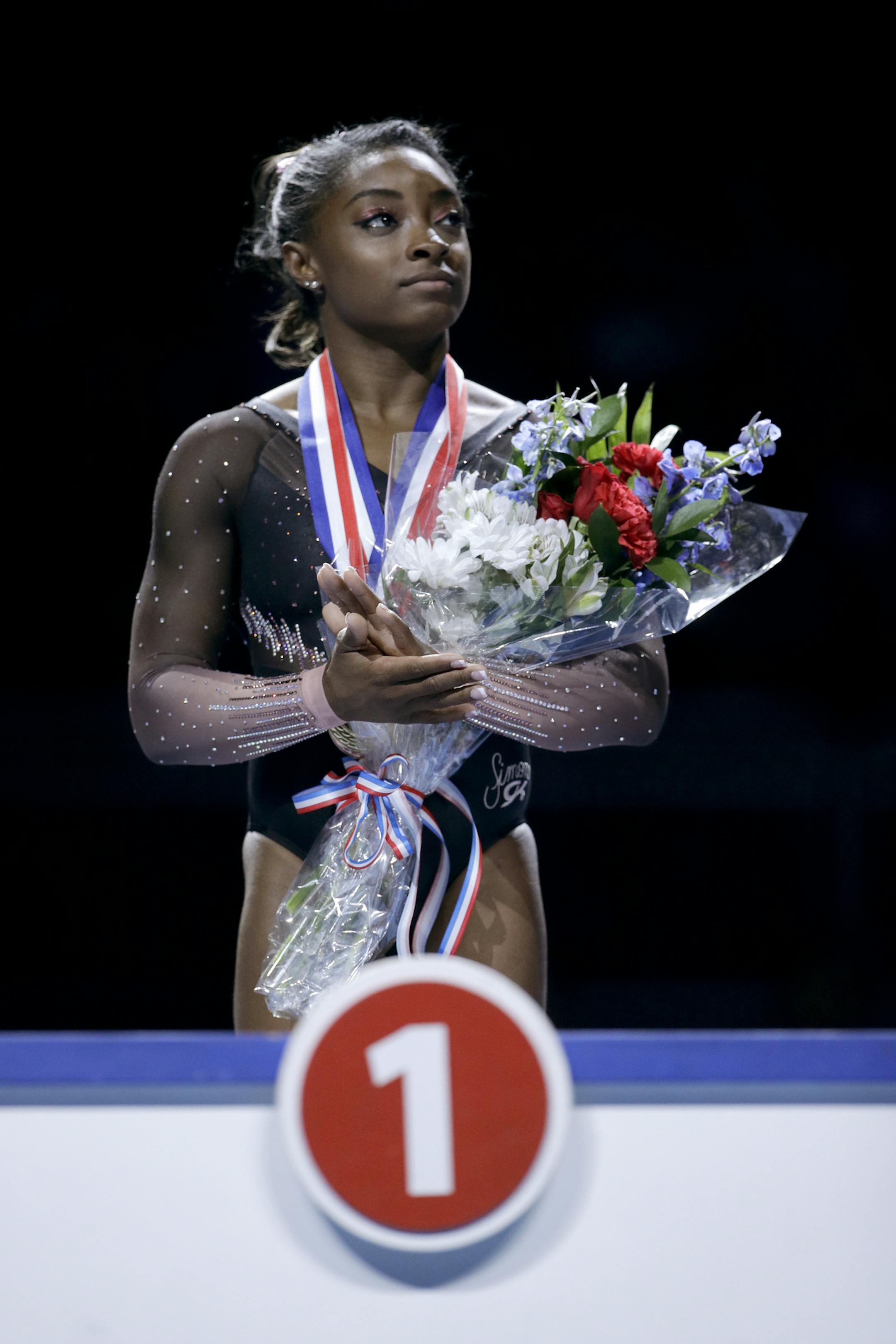 Simone Biles waits to be announced as the all-around winner after the senior women's competition at the 2019 U.S. Gymnastics Championships Sunday, Aug. 11, 2019, in Kansas City, Mo. (AP Photo/Charlie Riedel)