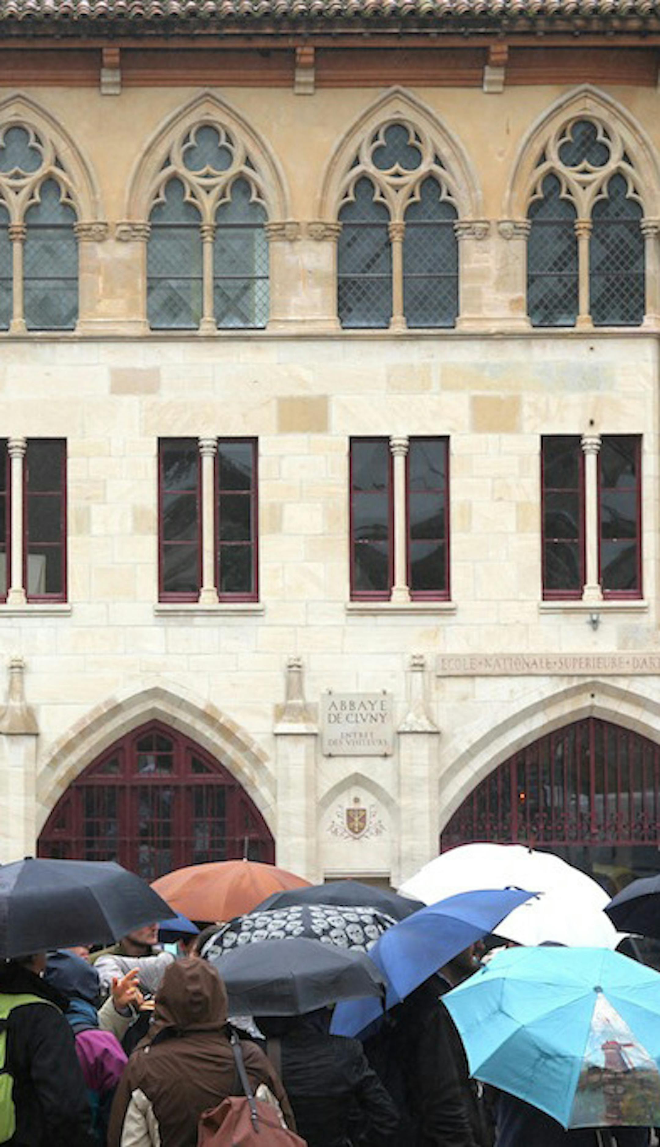 Tourists wait in the rain outside the Abbaye de Cluny. ] Photo by Alexander Besant, Hearst Newspapers
